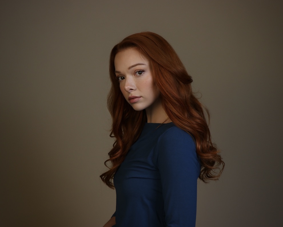 Courtney Sardana in a dramatic blue character headshot