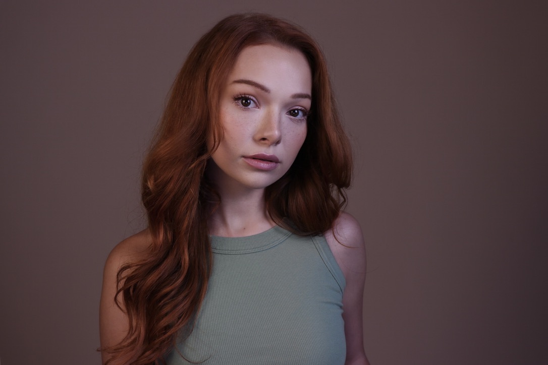 Courtney Sardana in a green dramatic headshot