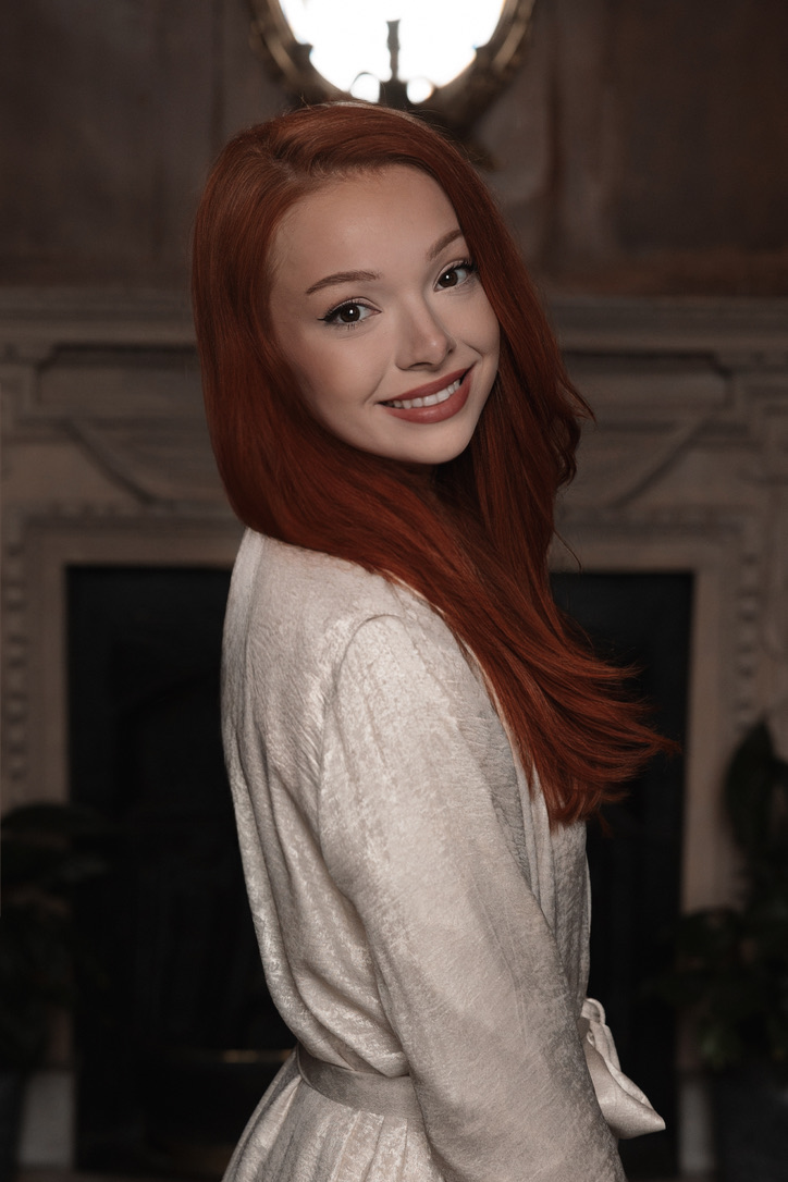 Courtney Sardana smiling in a cream editorial portrait