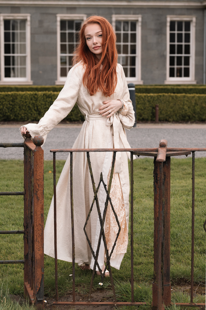 Courtney Sardana outdoors in a cream dress